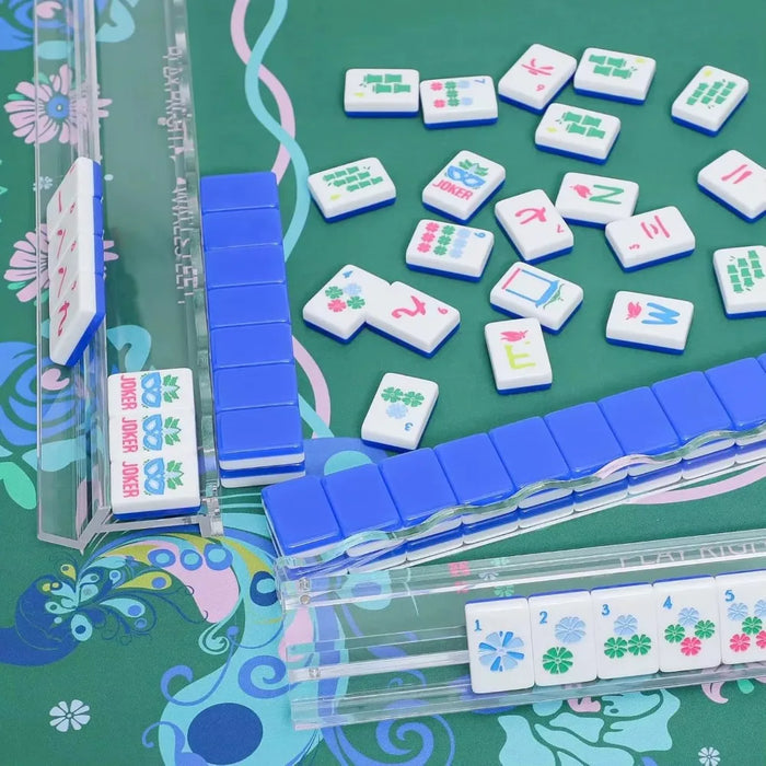 Clear acrylic mahjong racks holding tiles on a green mat